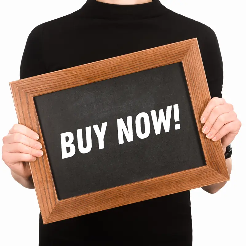 En man håller upp en skylt med texten 'buy now' i en reklam-liknande bild som symboliserar en direkt marknadsföringsstrategi. Vad är skillnaden mellan content marketing och reklam?